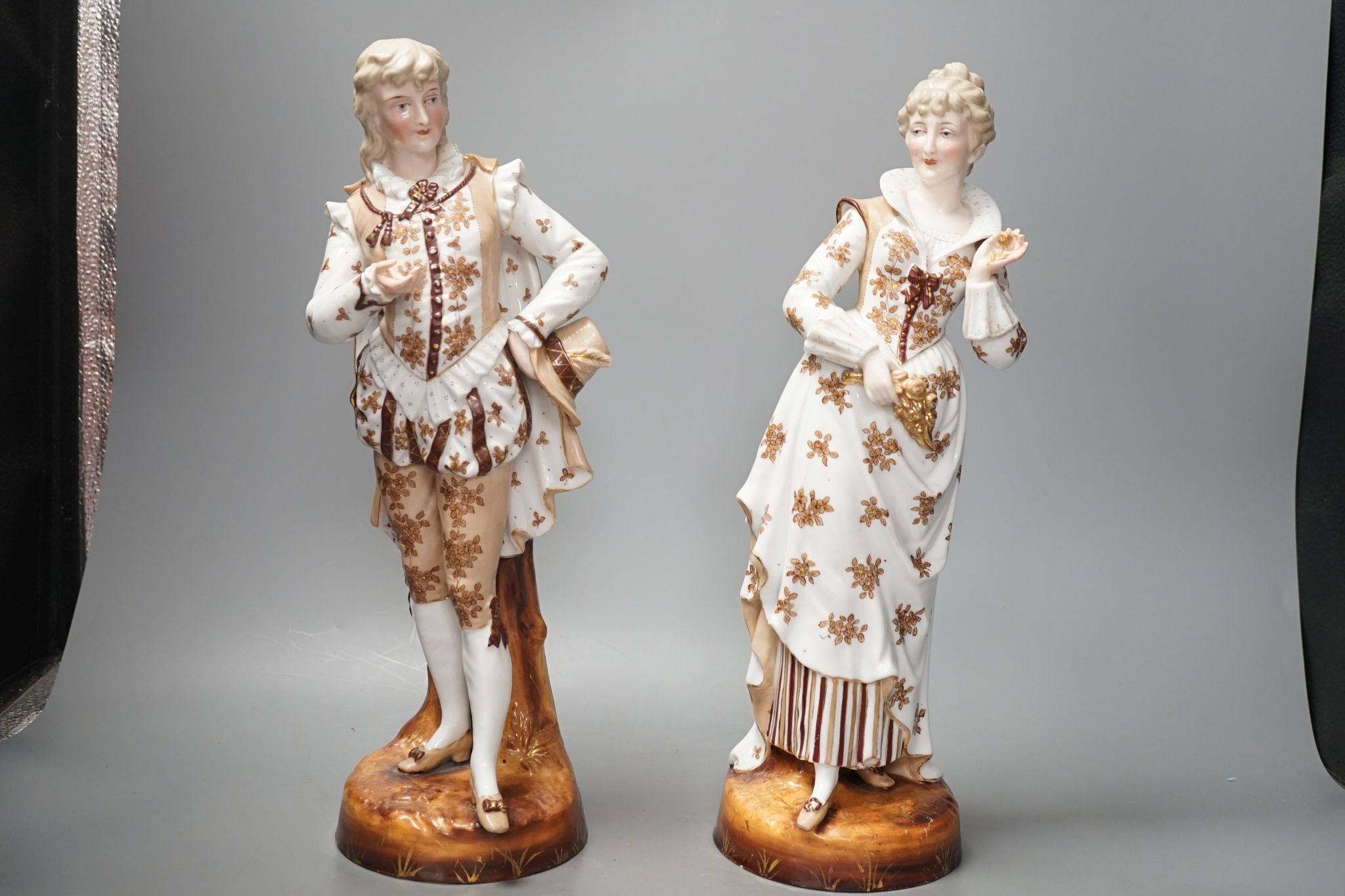 A pair of large French porcelain figures, 38cm, and a figural group en suite